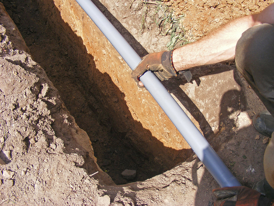 man installing water pipe in the soil